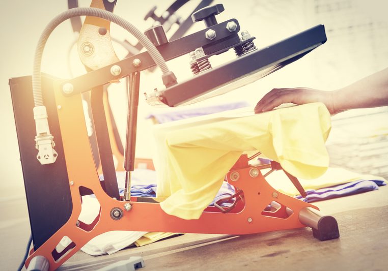 Man preparing t-shirt for printing in the silk screen printing machine